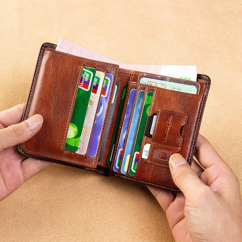 Brown leather wallet with multiple cards held open by hands on a beige background