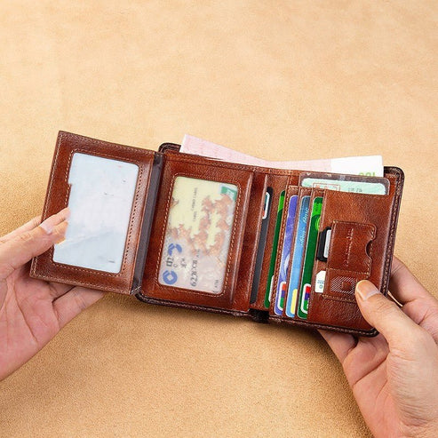 Brown leather wallet with various cards and a document held open by hands on a beige background